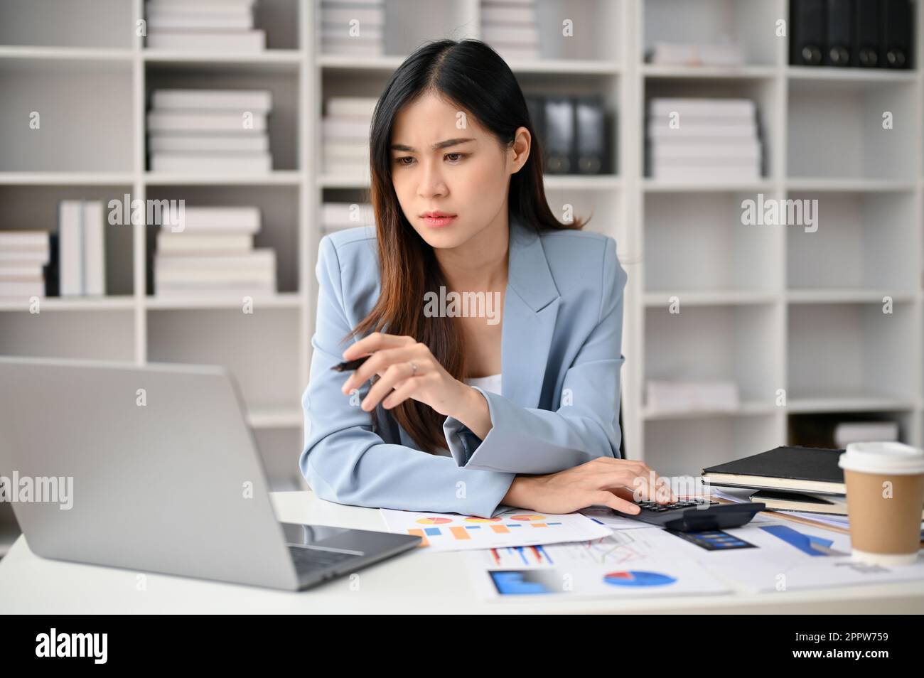 Professional and focused millennial Asian businesswoman looking at her ...