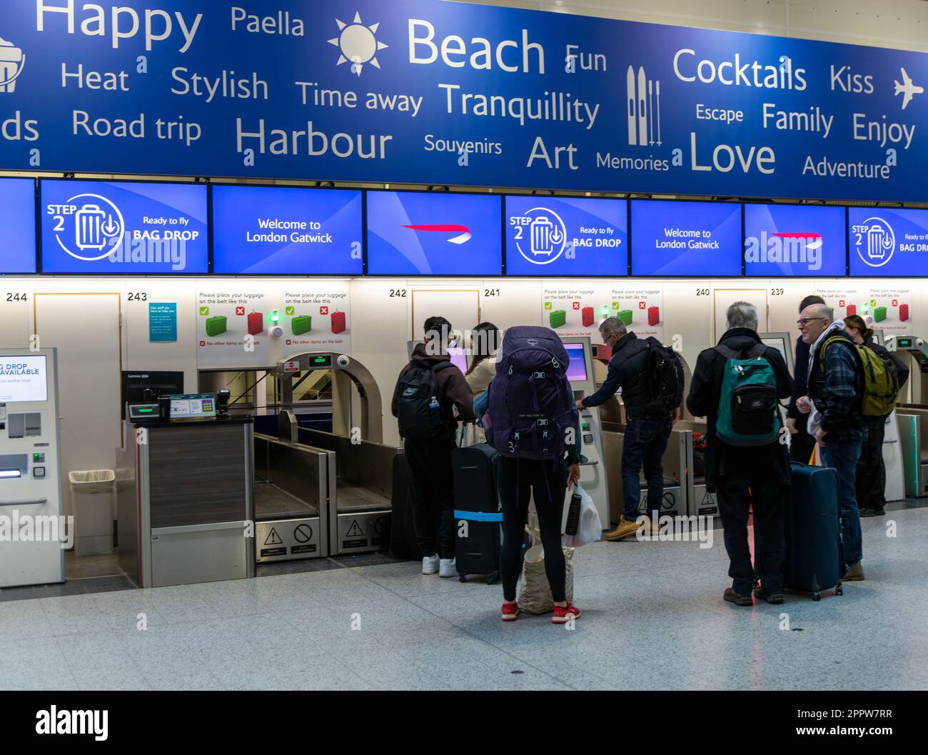 Passengers using British Airways automatic bag drop facilities inside