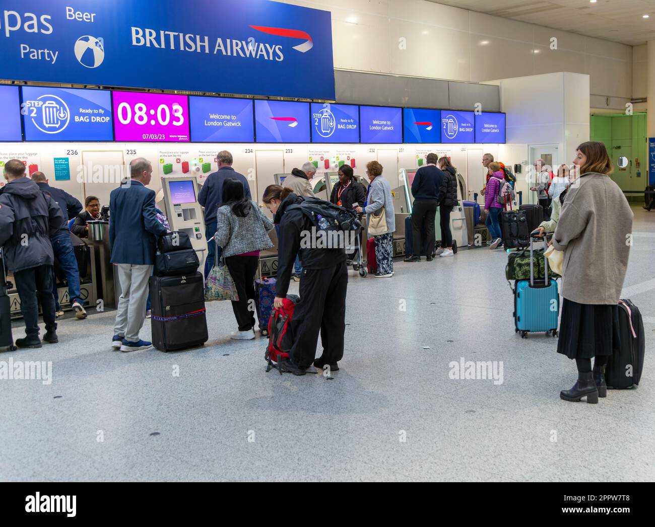 Passengers using British Airways automatic bag drop facilities inside