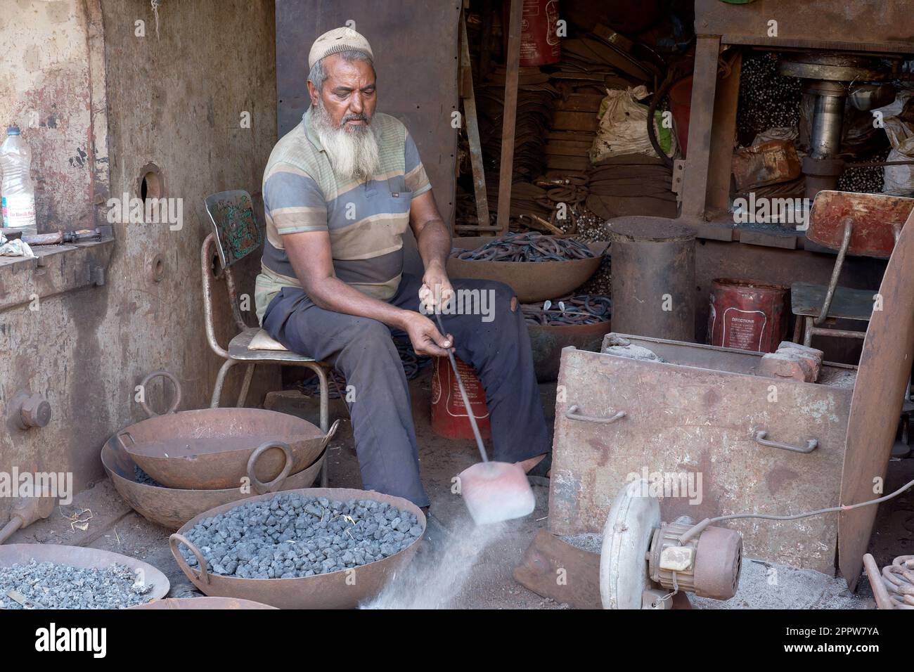 An ironsmith at work in Darukhana slum area, Mazagaon, Mumbai, India Stock Photo