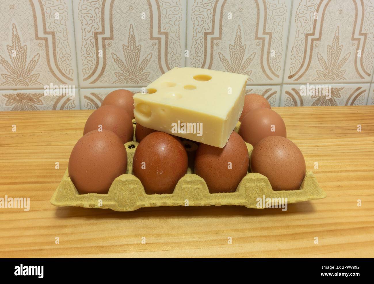 Emmental cheese and eggs on kitchen table. Rising food prices, cost of living...UK Stock Photo