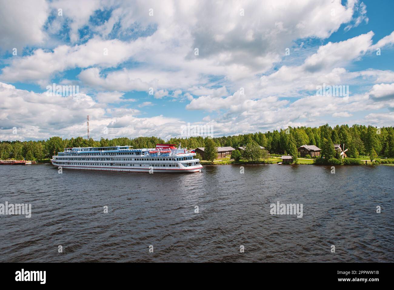 MANDROGI, RUSSIA - JUNE 8, 2015: Karelia region, old wooden houses on the banks of the Svir River. Restored ancient village, the berth of tourist ship Stock Photo