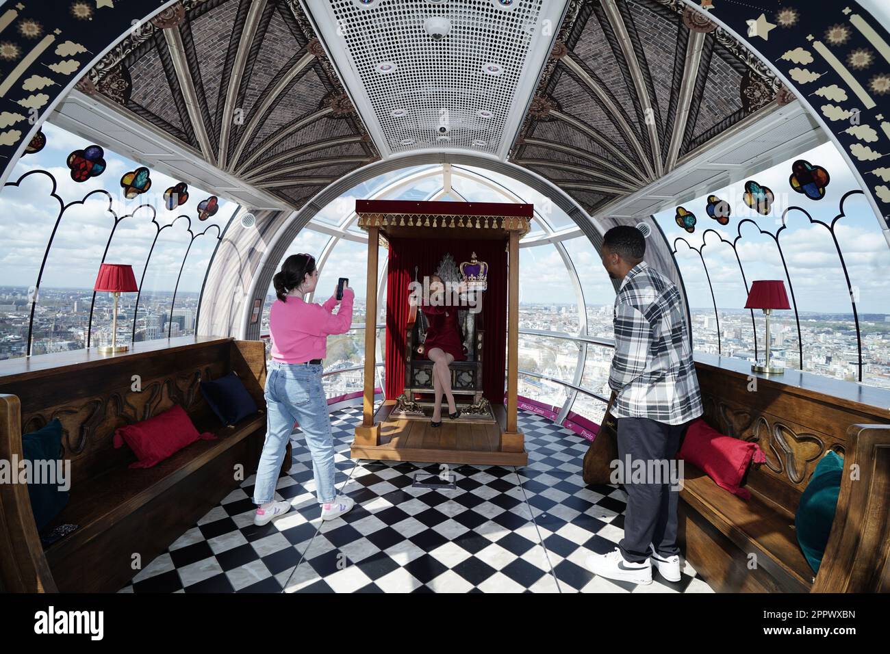 Historian Kate Williams has her picture taken inside a pod of the lastminute.com London Eye, in central London, which has been transformed into Westminster Abbey, complete with replica coronation chair and crown jewels, ahead of the coronation of King Charles III on the May 6. Picture date: Tuesday April 25, 2023. Stock Photo