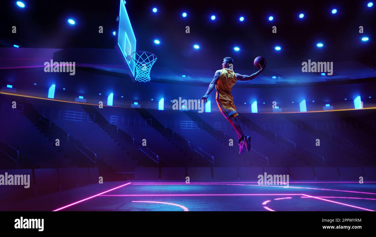 Scoring winning goal. Young man, professional basketball player in yellow uniform jumping