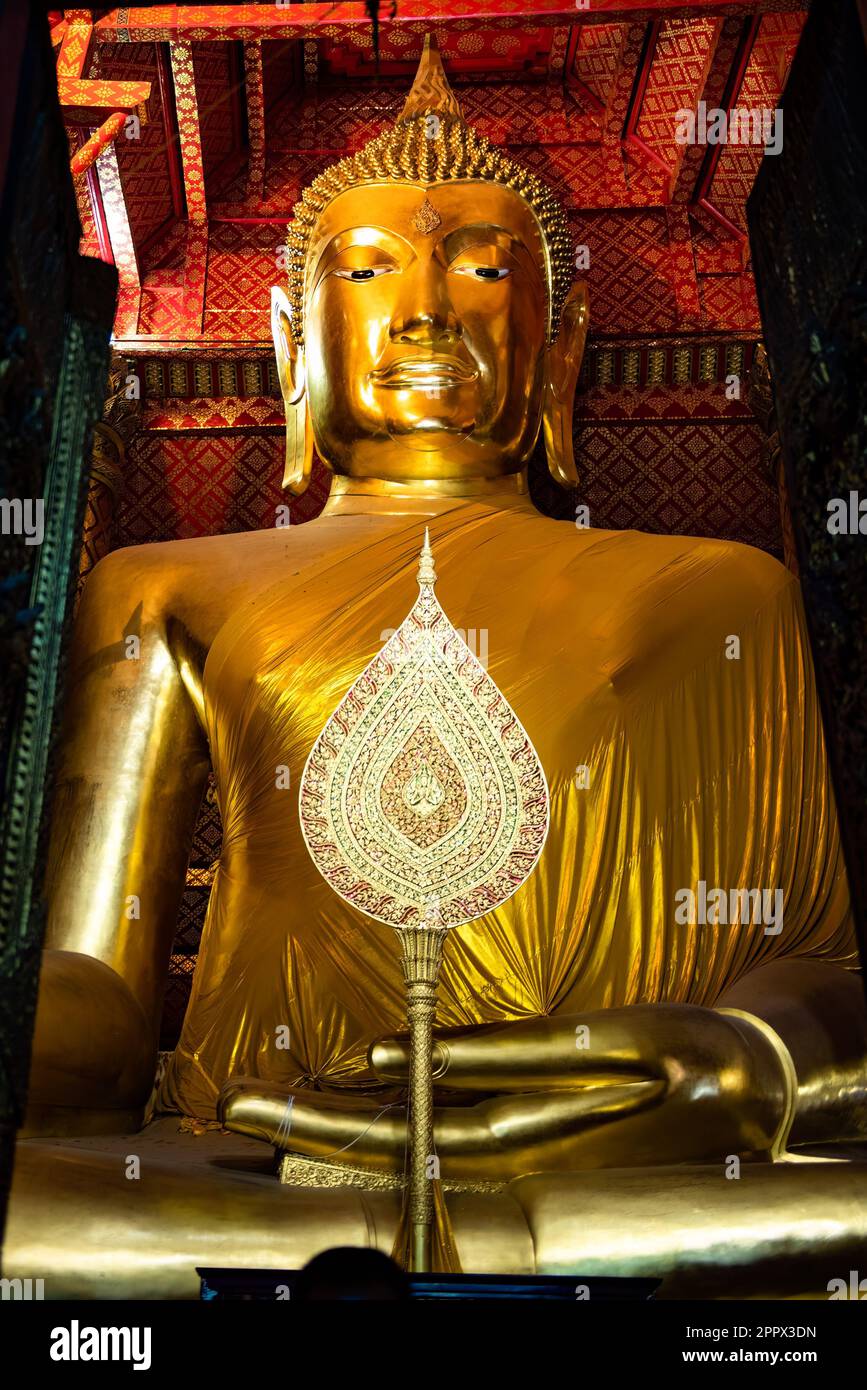 A golden statuette of Buddha in a peaceful pose inside a temple Stock ...