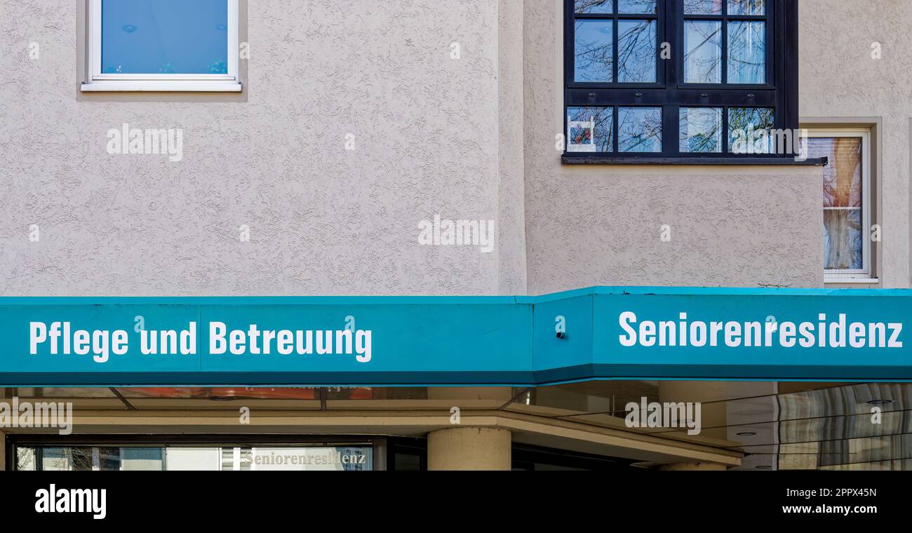 Sign on the wall of a nursing and retirement home. The text Pflege und Betreuung is German for nursing and care, Seniorenresidenz is German for senior Stock Photo