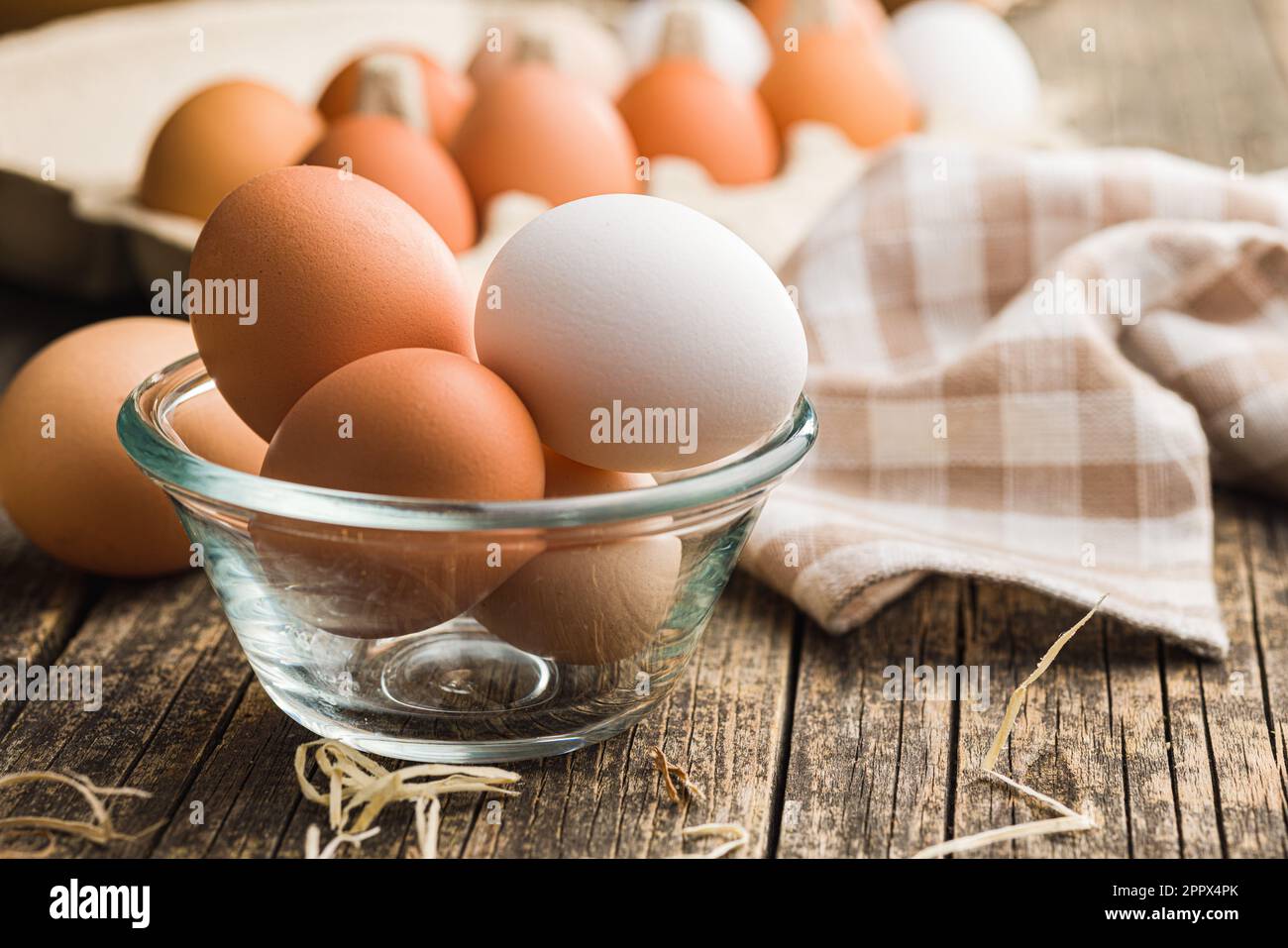 Whole chicken eggs in bowl on the wooden table. Stock Photo