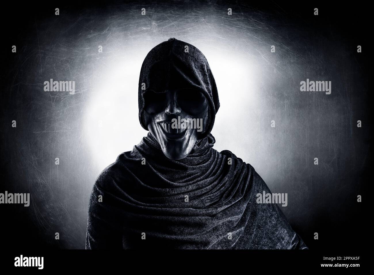 Scary figure with hooded cloak in the dark Stock Photo - Alamy
