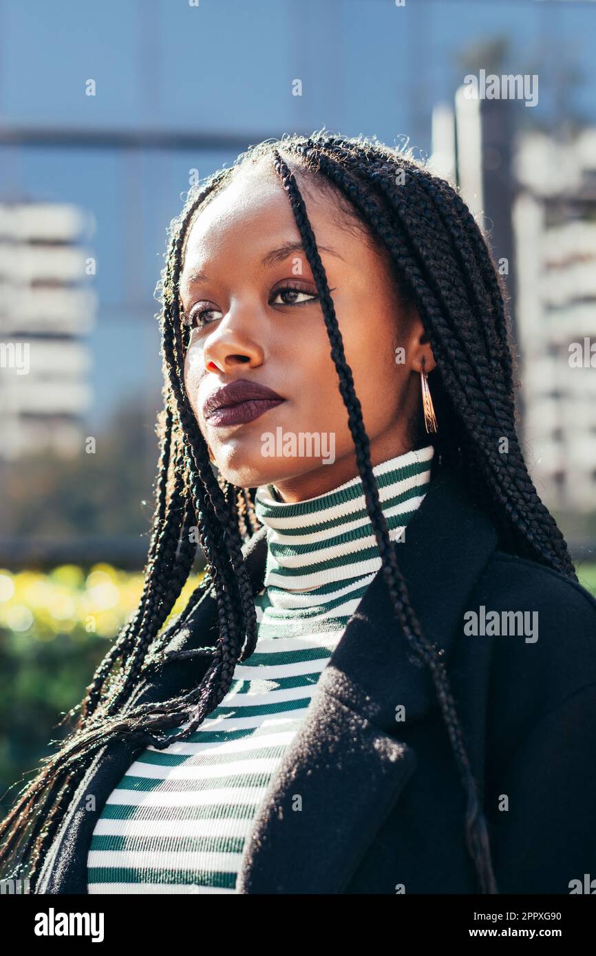 African American female with Afro braids standing on city street and ...
