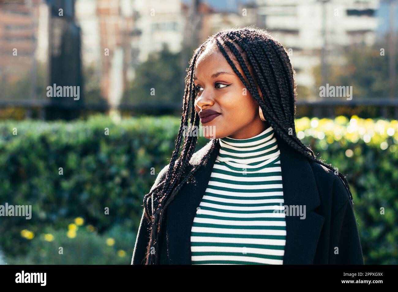African American female with Afro braids standing on city street and ...