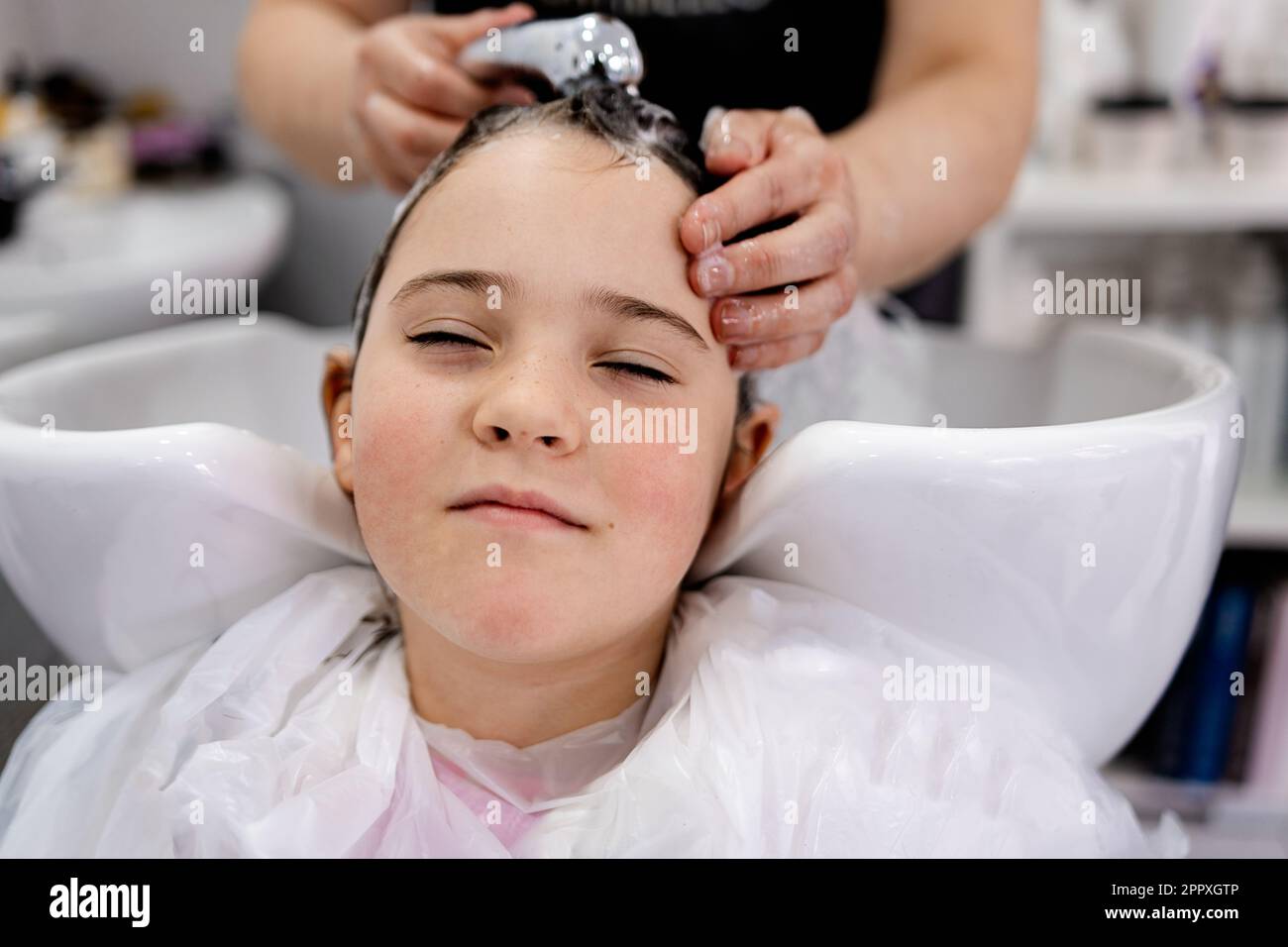 Happy child looking at camera with half closed eyes while relaxing with
