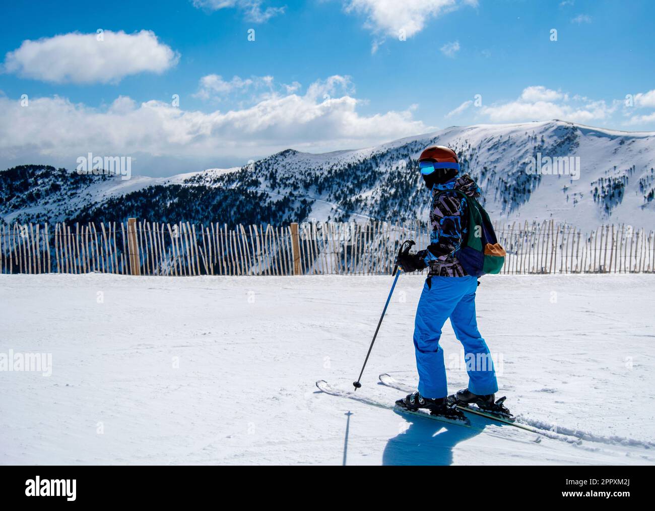Full body side view of unrecognizable skier in warm ski suit and