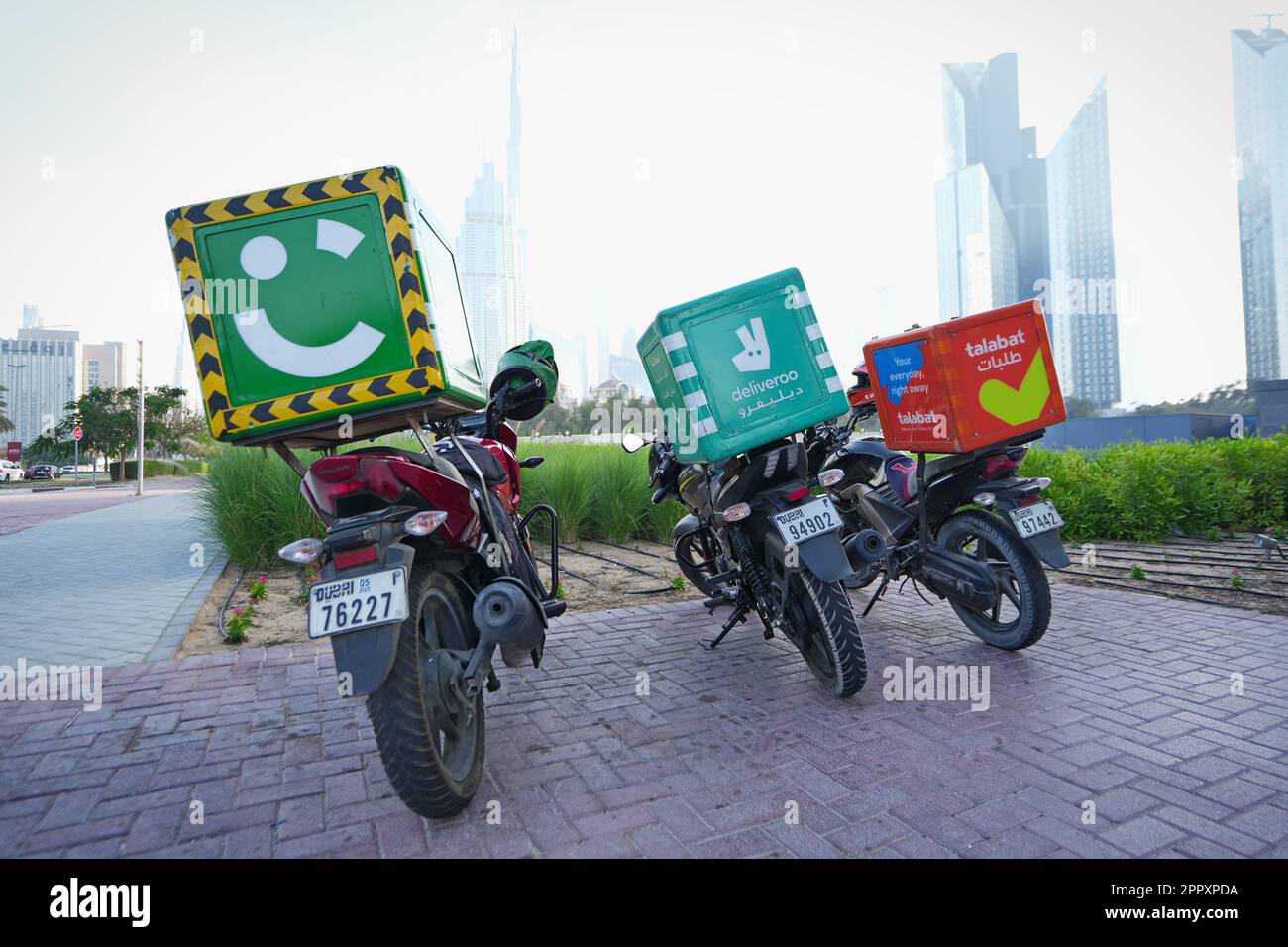 Motorcycle food delivery at parking lot. Dubai, United Arab Emirates - April 2023 Stock Photo