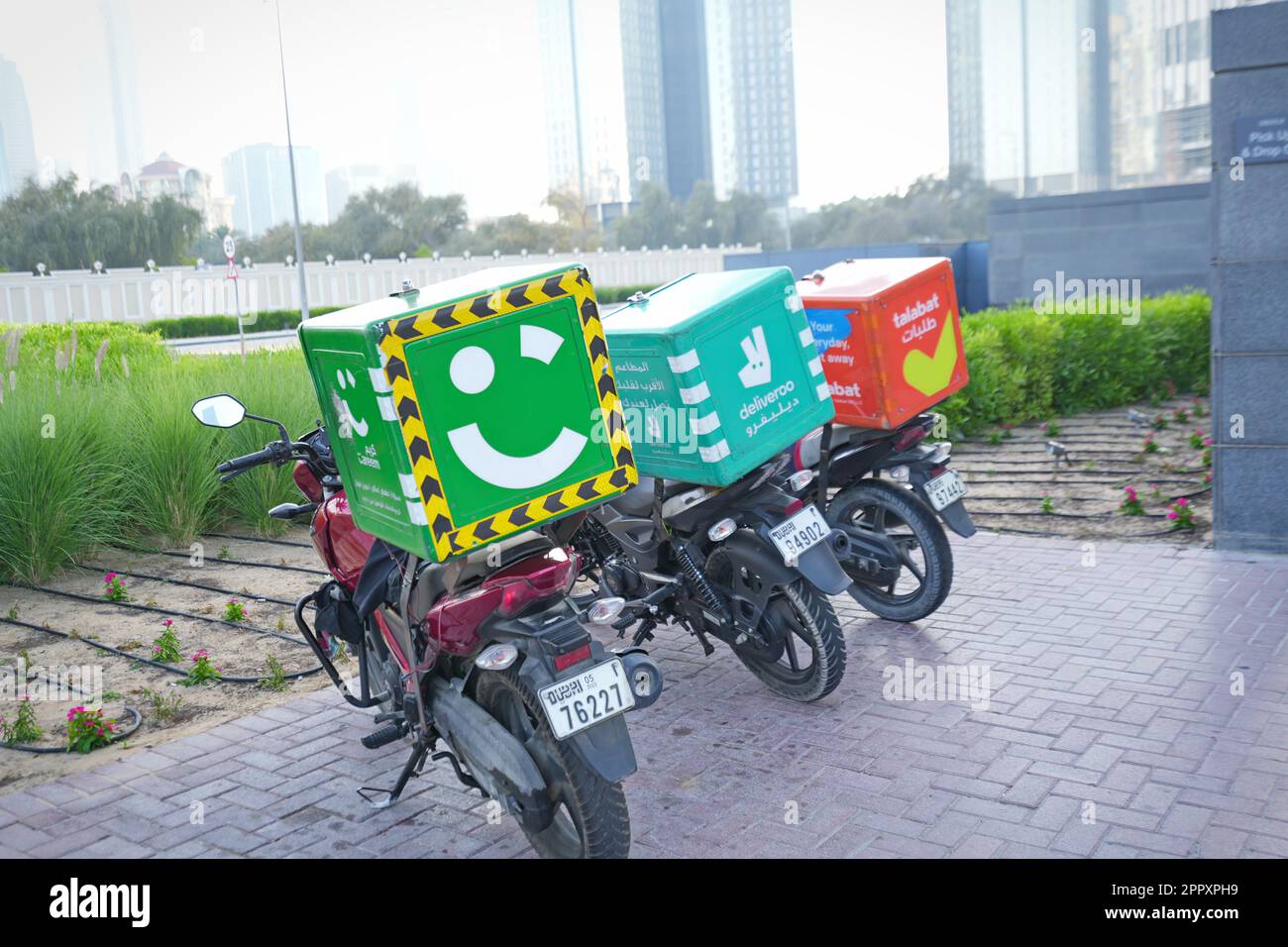 Motorcycle food delivery at parking lot. Dubai, United Arab Emirates - April 2023 Stock Photo