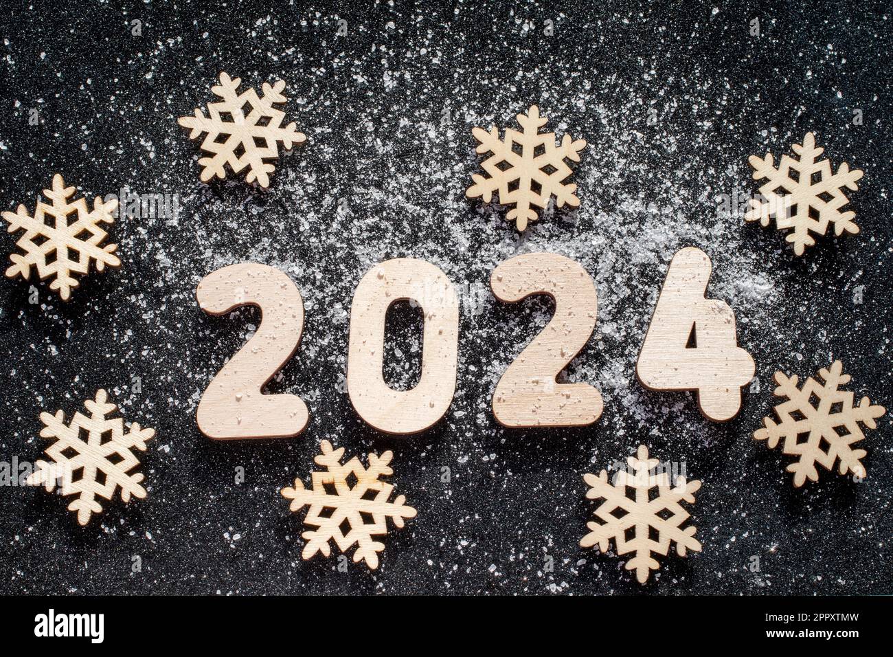 New Years concept - Wooden snowflakes and numbers 2024 sprinkled with ...