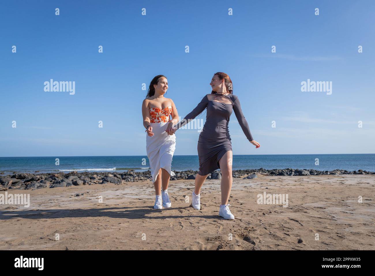 Two sisters hold hands and run at the beach, sister love Stock Photo ...
