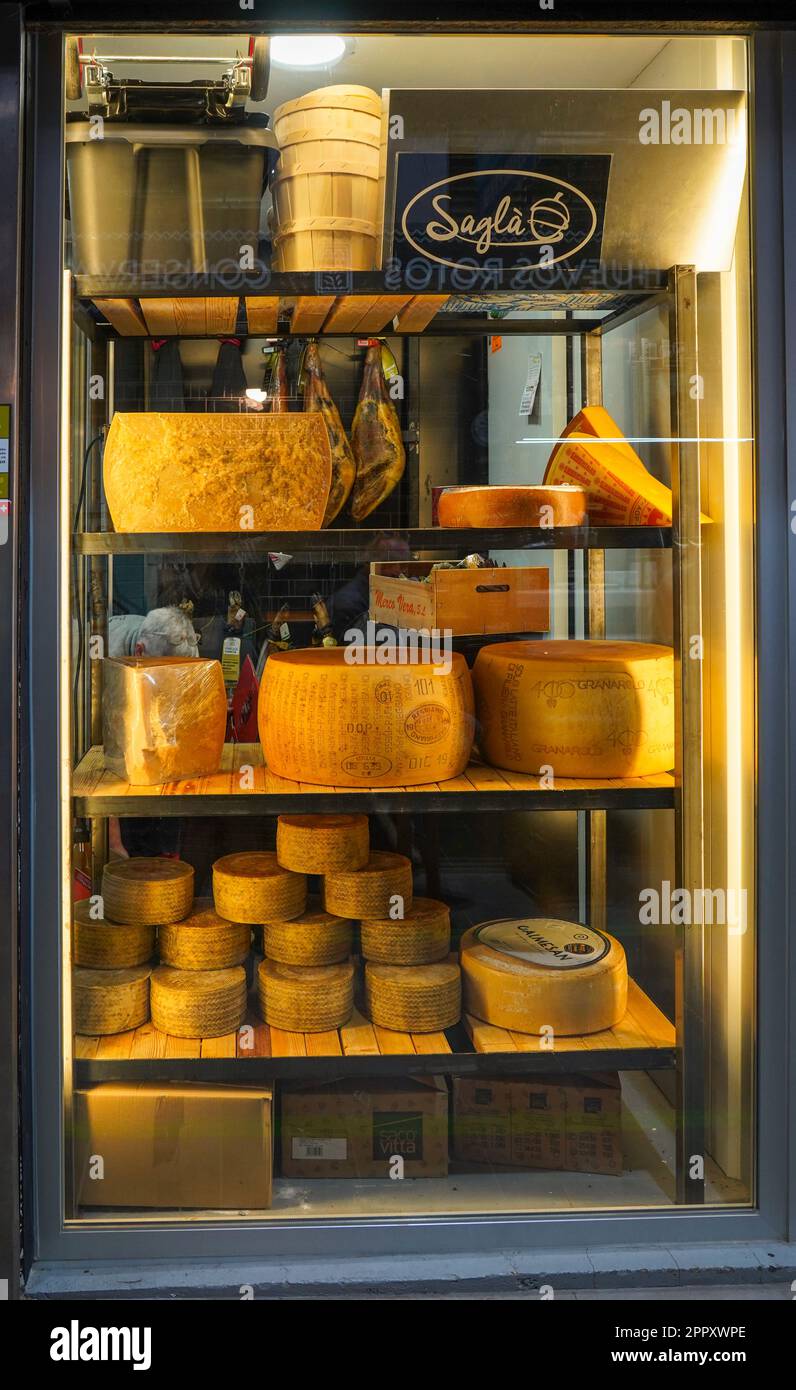 Parmesan cheese wheels on display in a fridge, Italian food store