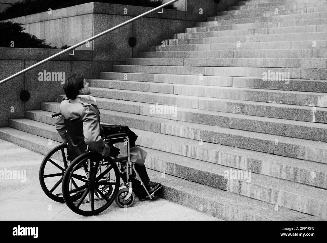 Black and white image of an Executive in a wheelchair facing very challenging situation Stock Photo