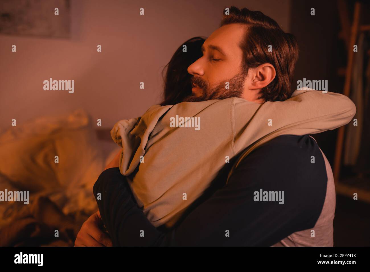 caring man hugging and calming down girlfriend at home in evening,stock image Stock Photo
