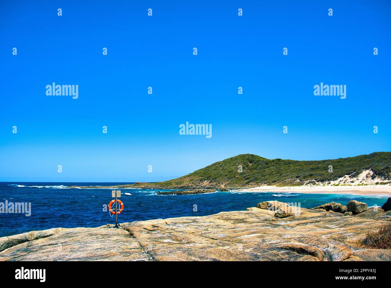 Rocky coast, heath covered hills and beach in William Bay National Park, Western Australia. Lifebuoy on a rock. Stock Photo
