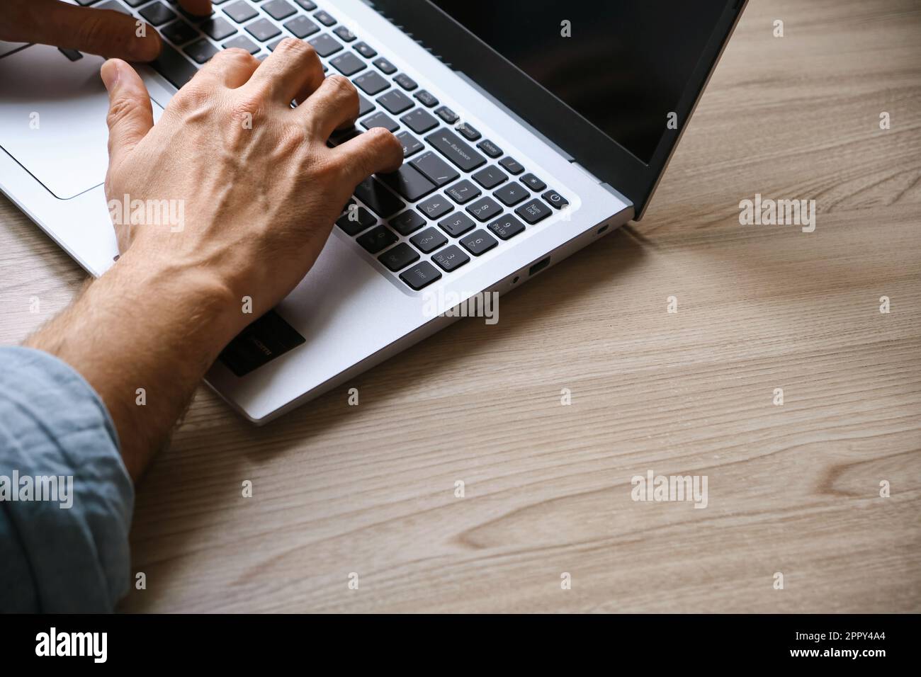 Man's hands typing on laptop keyboard top view Stock Photo
