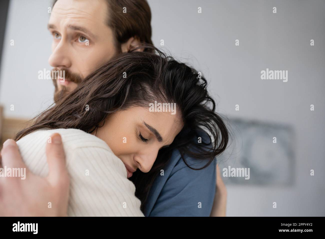 Caring man hugging and consoling sad brunette girlfriend at home,stock image Stock Photo
