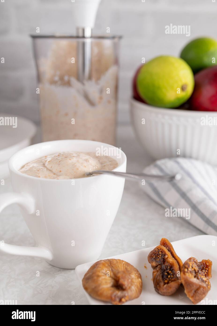Yogurt with dried figs in a cup on kitchen counter Stock Photo