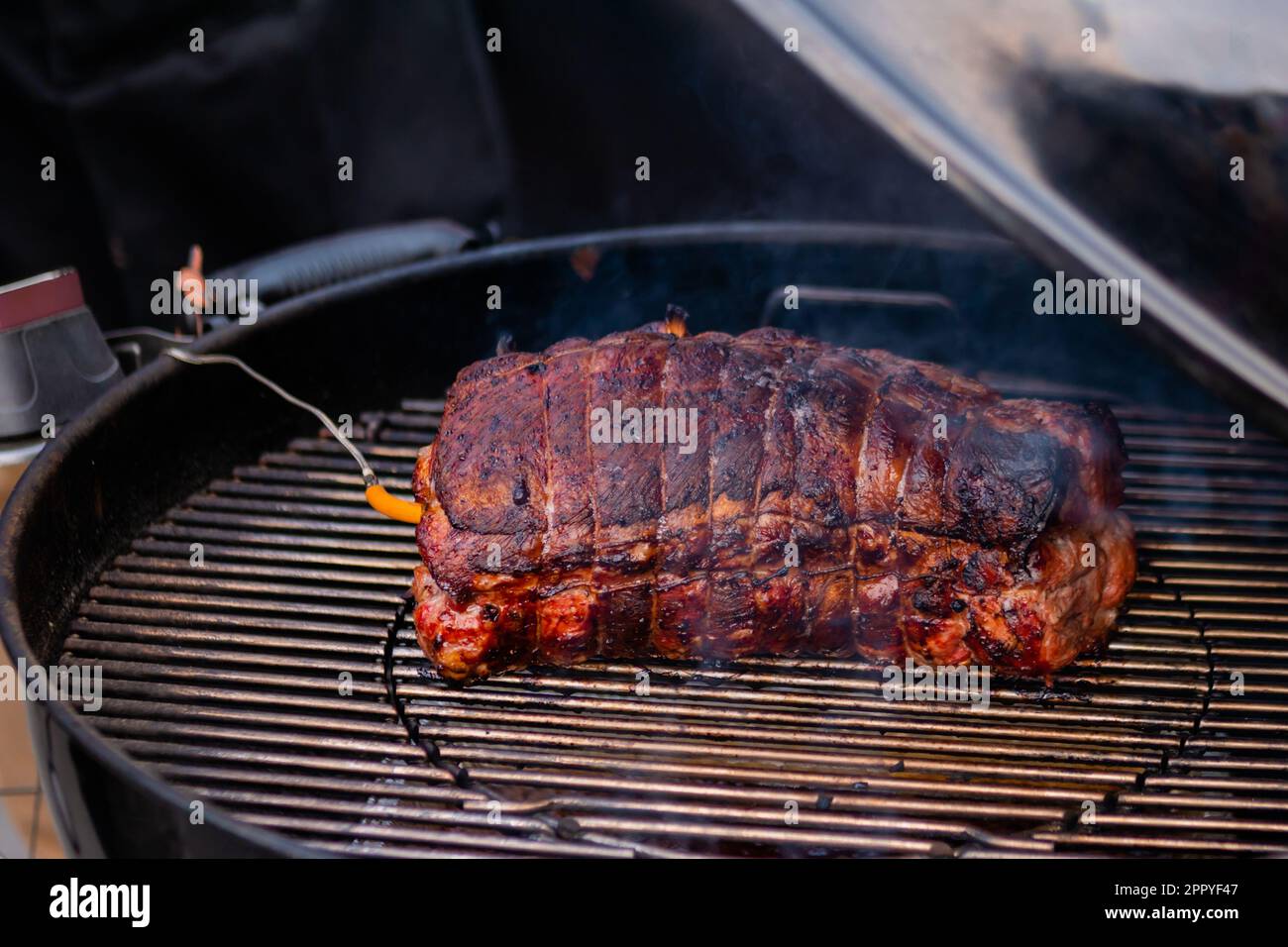 Process of cooking piece of meat with temperature probe on grill - street food Stock Photo