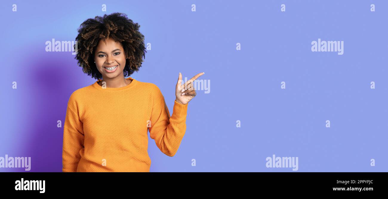Cheerful attractive african woman showing empty space Stock Photo - Alamy