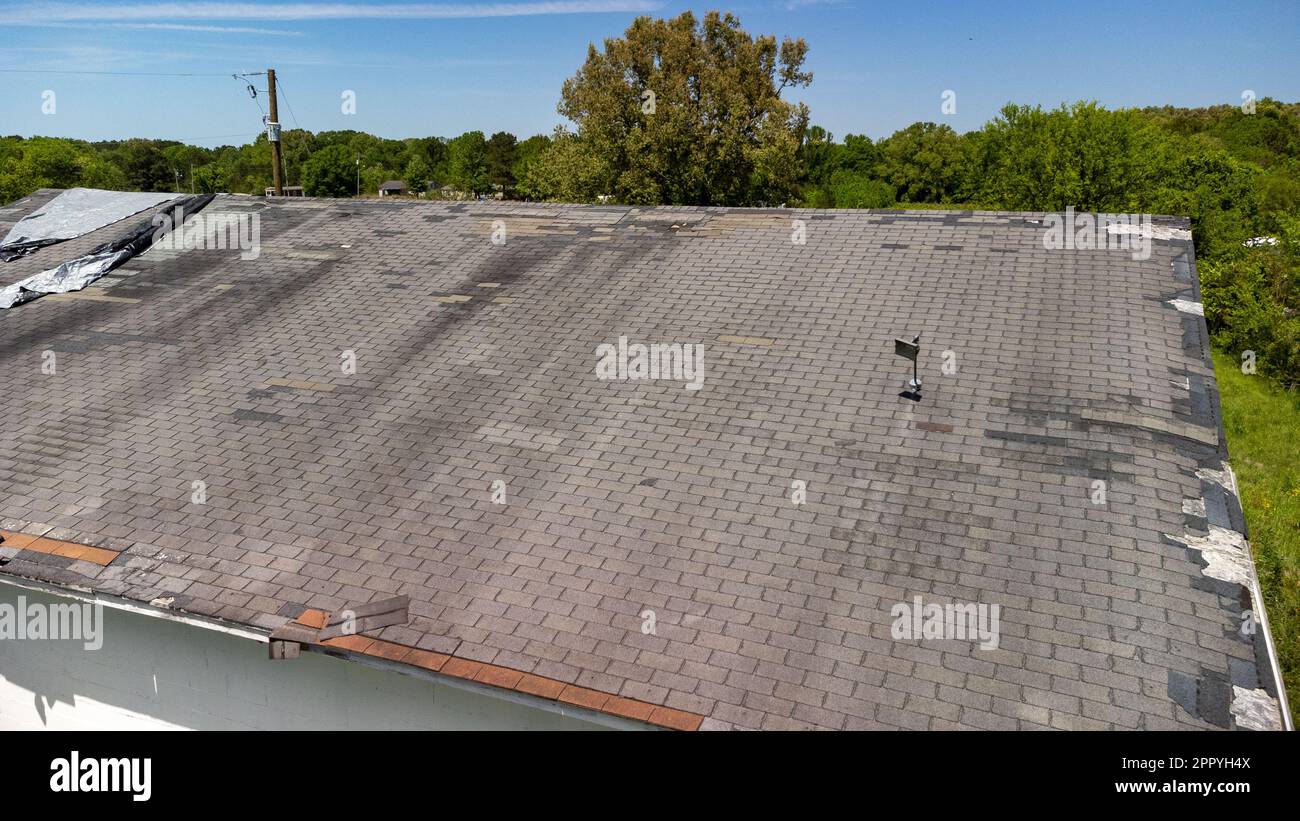Roof missing shingles due to age, weather and storm damage Stock Photo