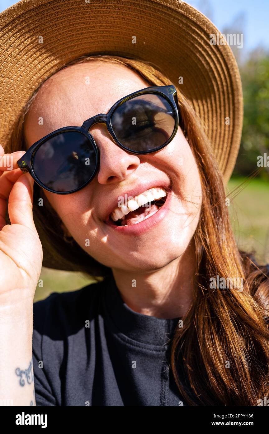 Young woman wearing straw hat laughing hi-res stock photography and ...