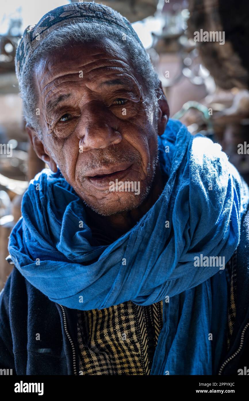 Portrait of an old Berber man dressed in typical clothes of his ethnic group at the door of his shop. Stock Photo