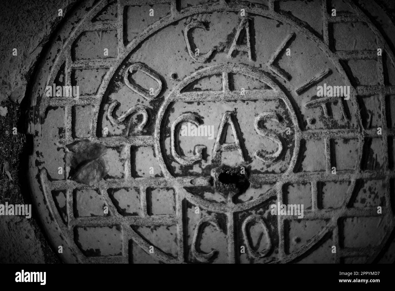 Black and white photograph of a SoCal Gas pavement cover in Costa Mesa