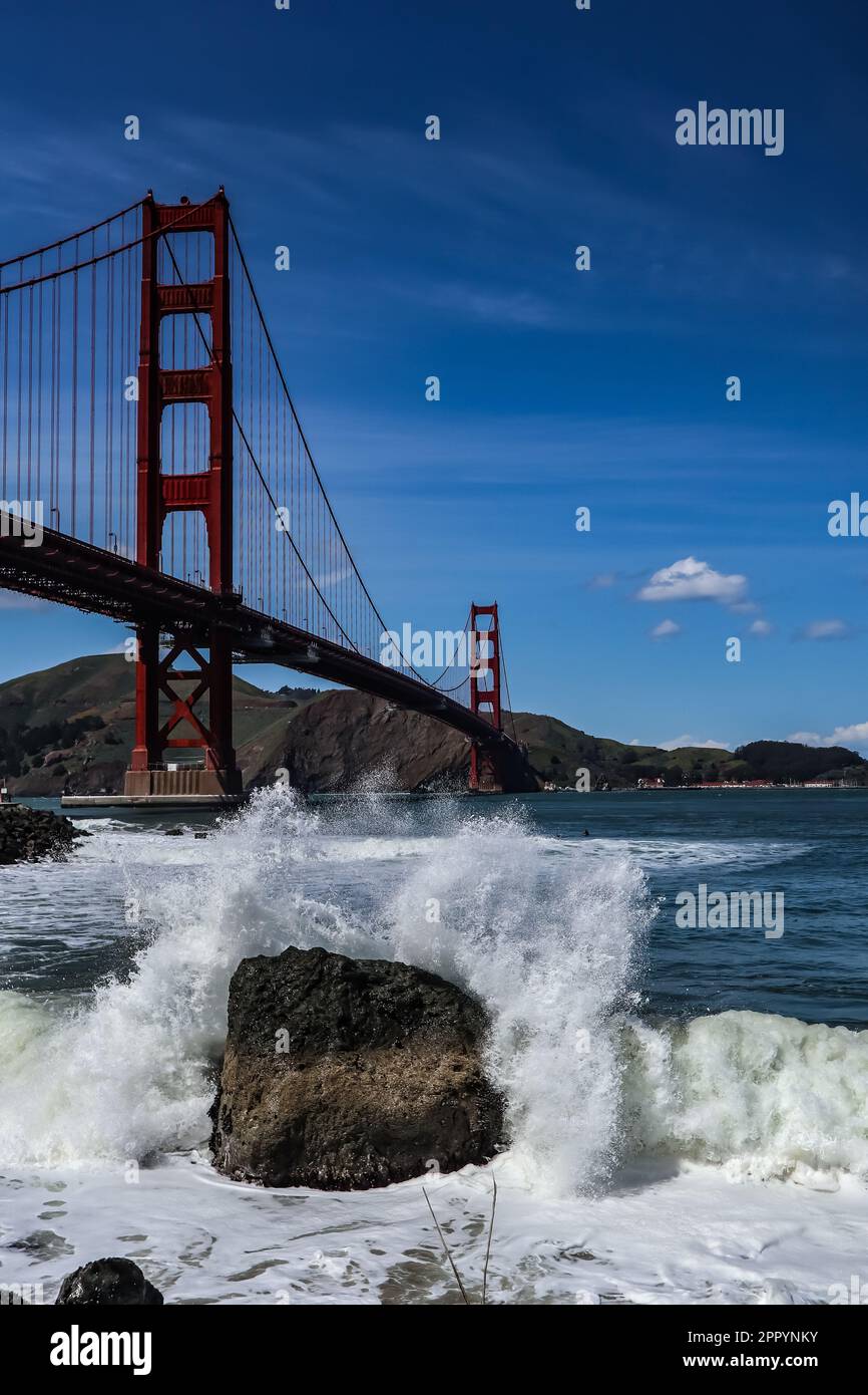 A scenic view of the iconic Golden Gate Bridge near crashing waves in San Francisco, California Stock Photo