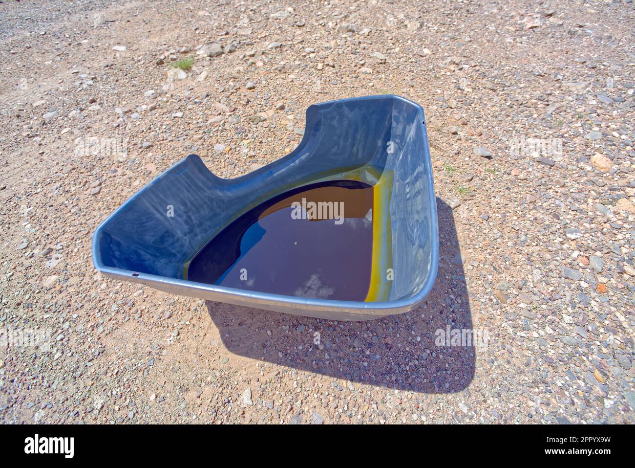 A plastic cat litter pan that has been repurposed into a drain pan for