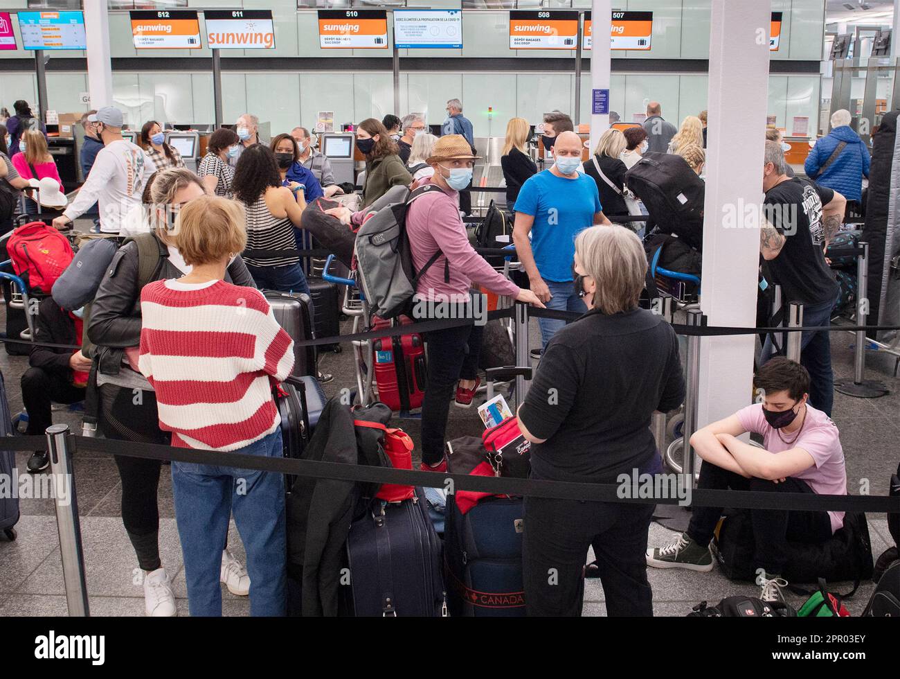 Montreal, Canada. 20th Apr, 2022. Travellers wait in line at a checkin