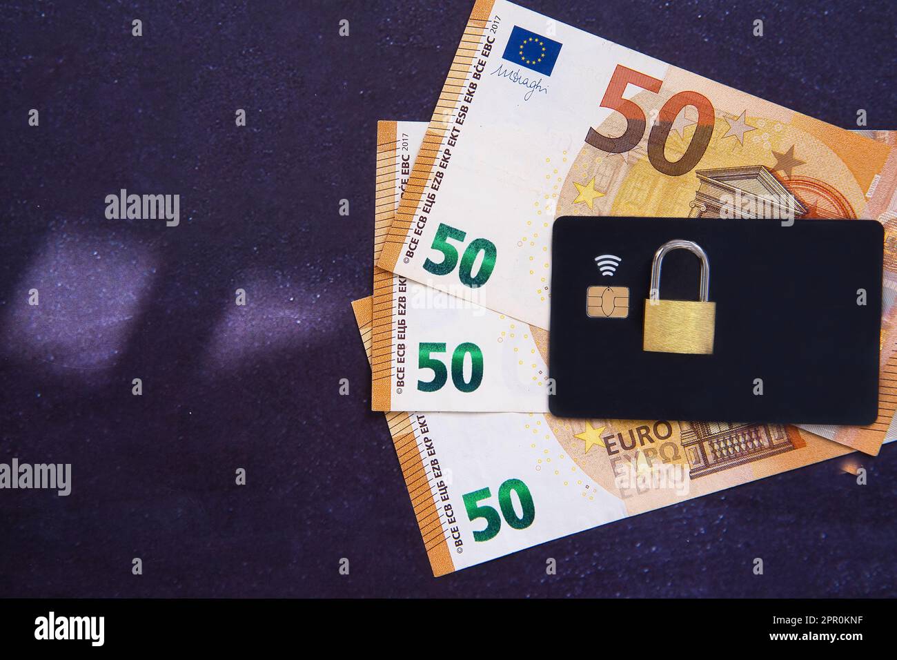 Reduction of spending and consumption due to the crisis. Padlock on money and credit card as a metaphor for blocking the consumption of products, food Stock Photo