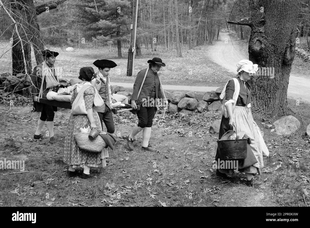 Revolutionary war actors dressed in period clothing reenacting Parkers Revenge caring a sick child in the Minuteman National Historic Park on Patriots Stock Photo