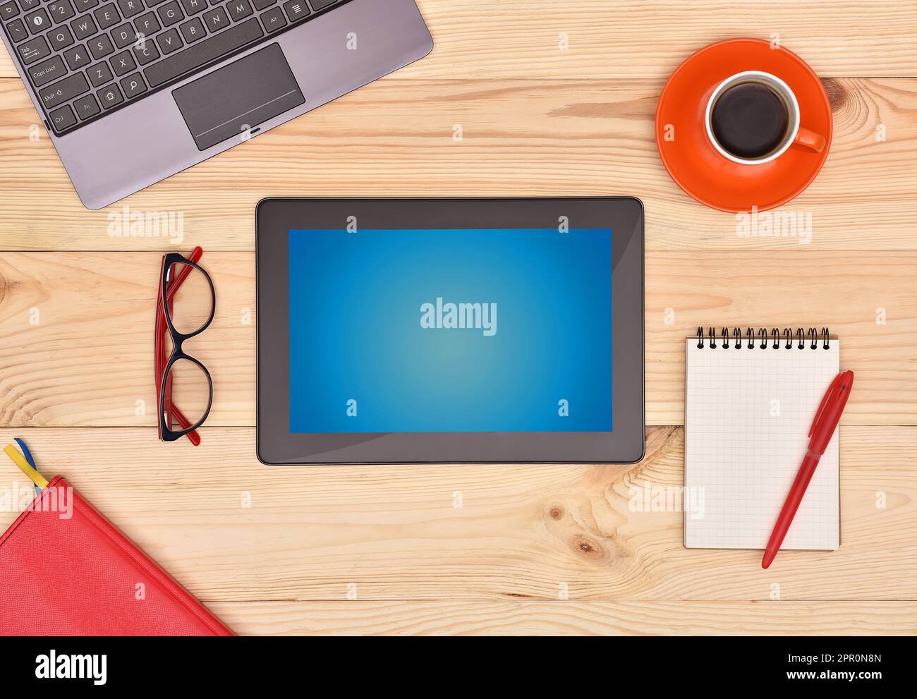 Digital Touch pad with blank screen and many business objects on wooden