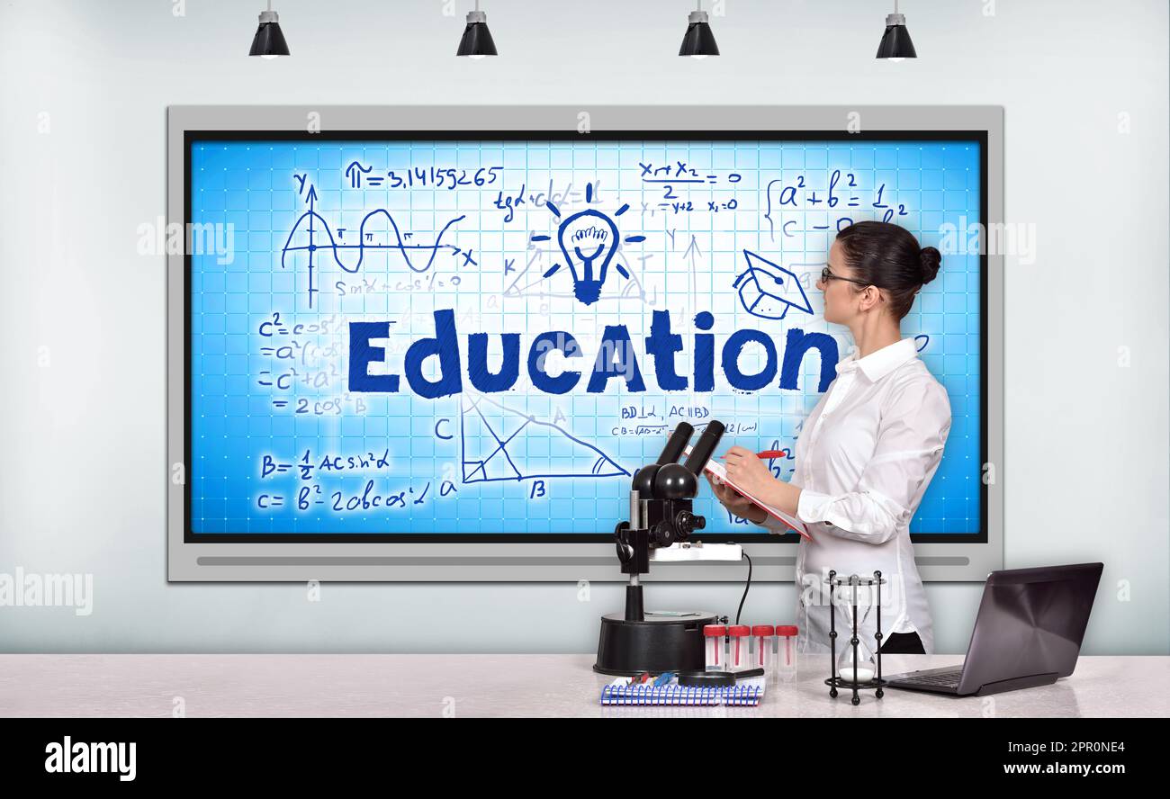 teacher woman sitting in laboratory and looking on tv screen Stock Photo