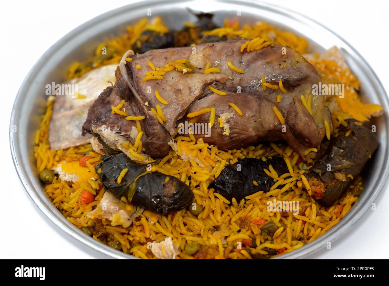 A well cooked lamb shank with yellow Basmati rice and mixed vegetables