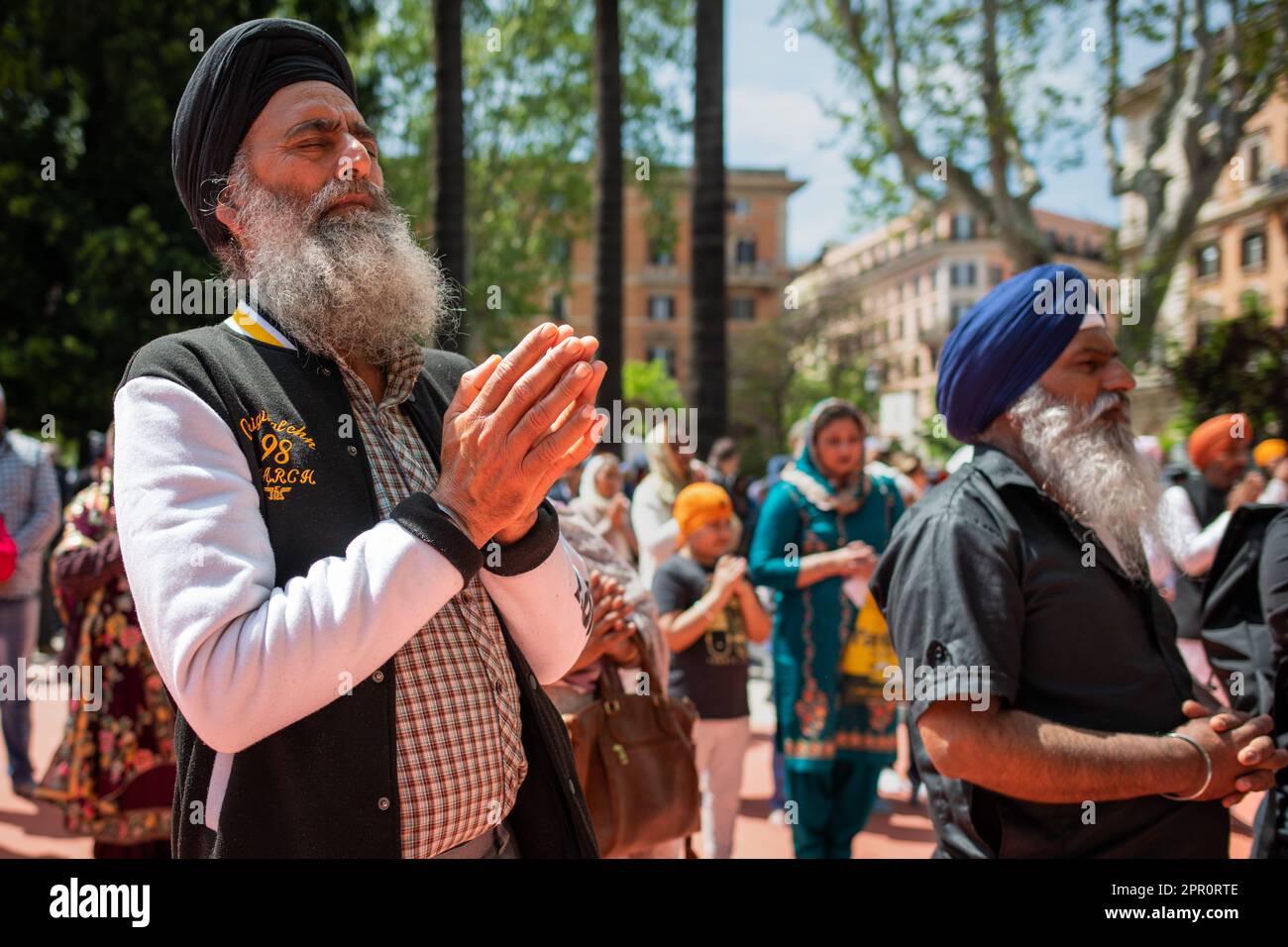 An elderly Sikh with a turban prays during the procession for the