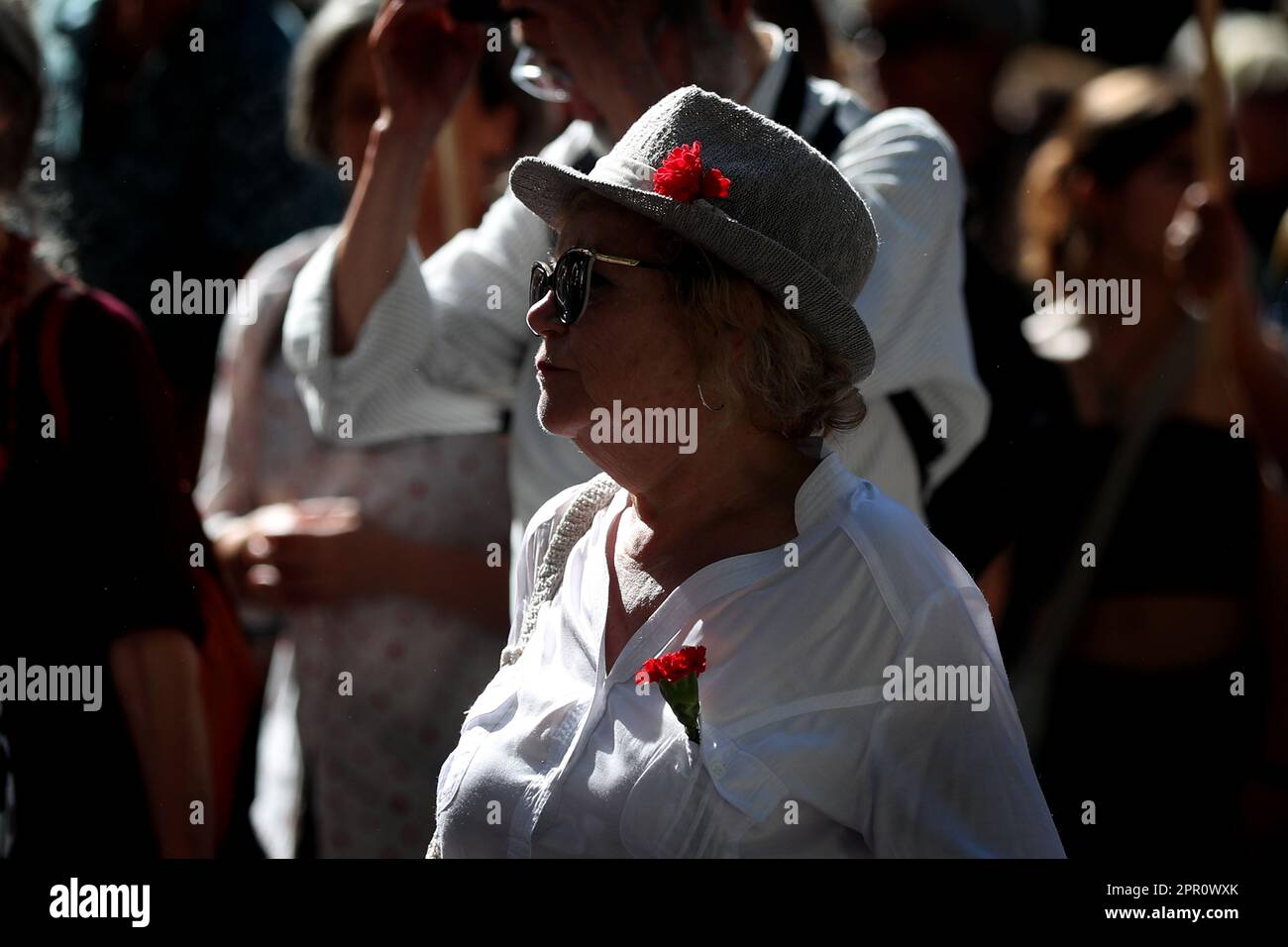 Lisbon, Portugal. 25th Apr, 2023. A woman wearing red carnations, symbol of the Portuguese