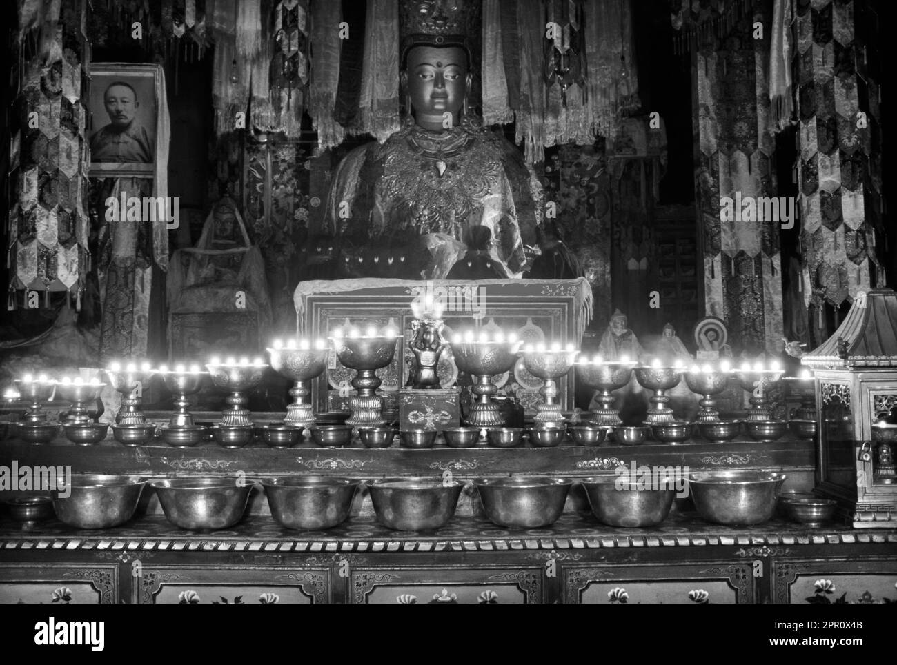 BUTTER LAMPS & SHAKYAMUNI STATUE inside the main temple at SAMYE MONASTERY known as SAMYE UTSE - TIBET Stock Photo