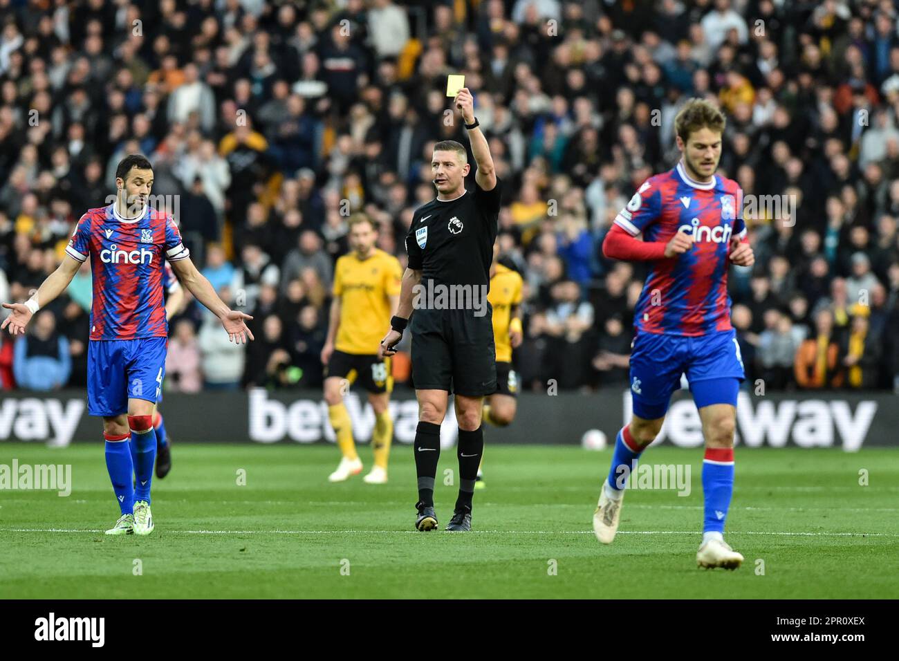 [25th April 2023;  Molineux Stadium, Wolverhampton, West Midlands, England; Premier League Football, Wolverhampton Wanderers versus Crystal Palace; Referee Robert Jones gives a yellow card to Luka Milivojevic of Crystal Palace Stock Photo