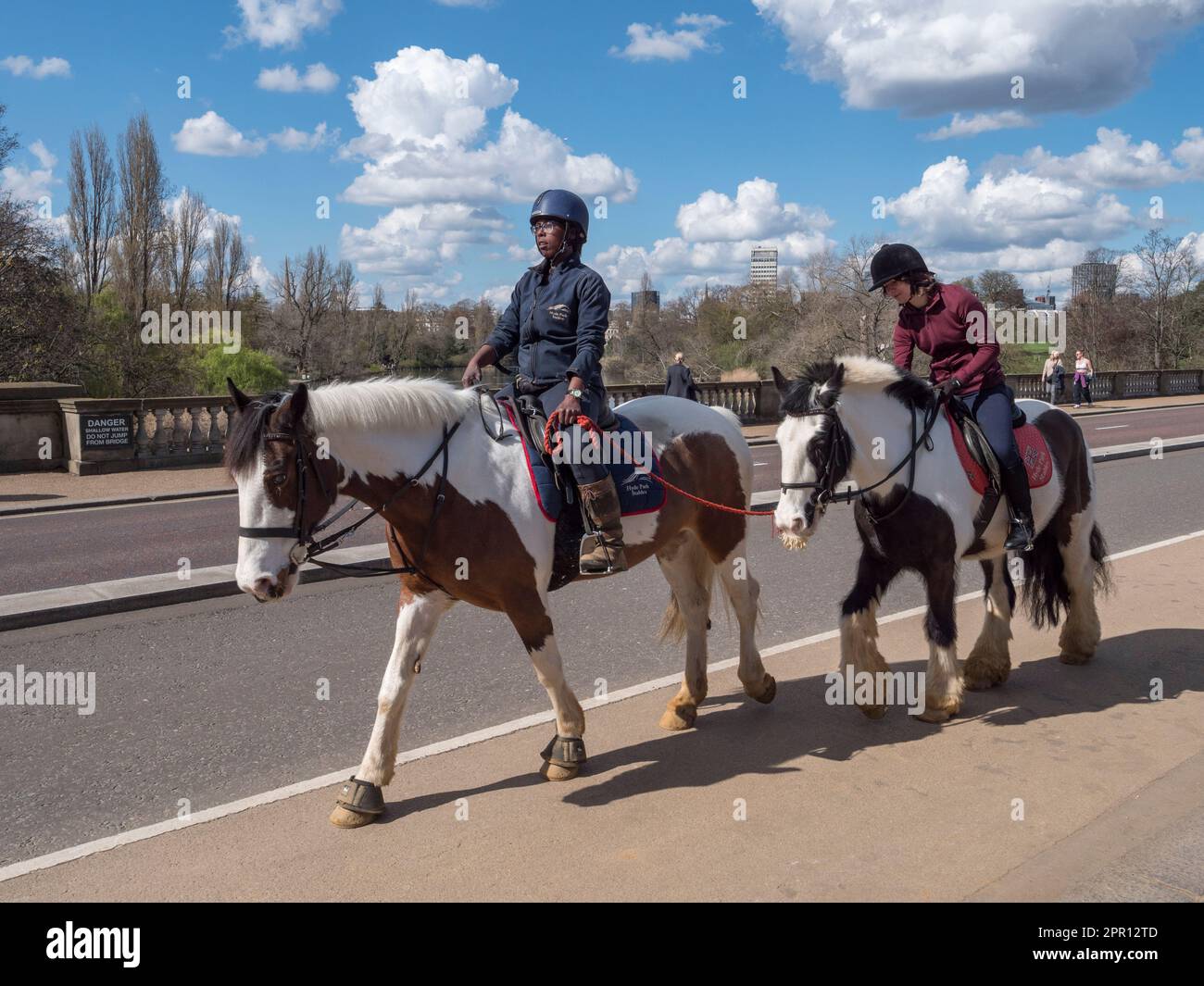 A pair riding ponies through Kensington Gardens, London, UK. Stock Photo