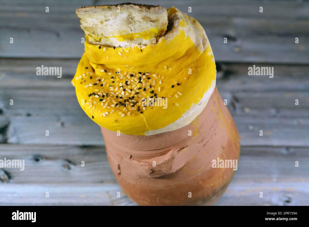 A pottery hot pot Jar covered with dough, sesame and lamb shank is inside it with Basmati rice and mixed vegetables and stuffed grape leaves mahshi Ma Stock Photo