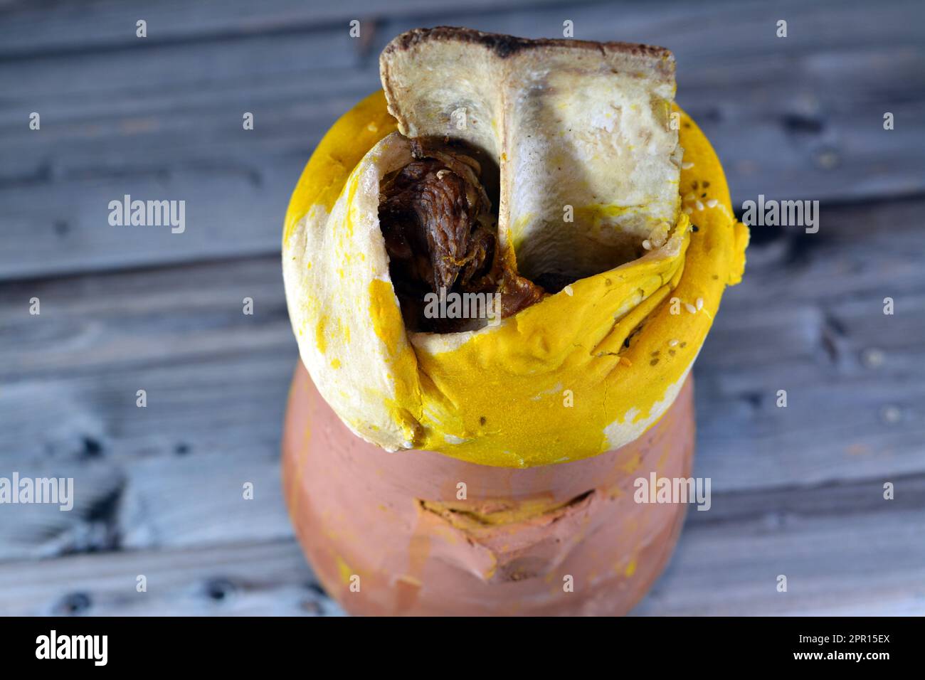 A pottery hot pot Jar covered with dough, sesame and lamb shank is