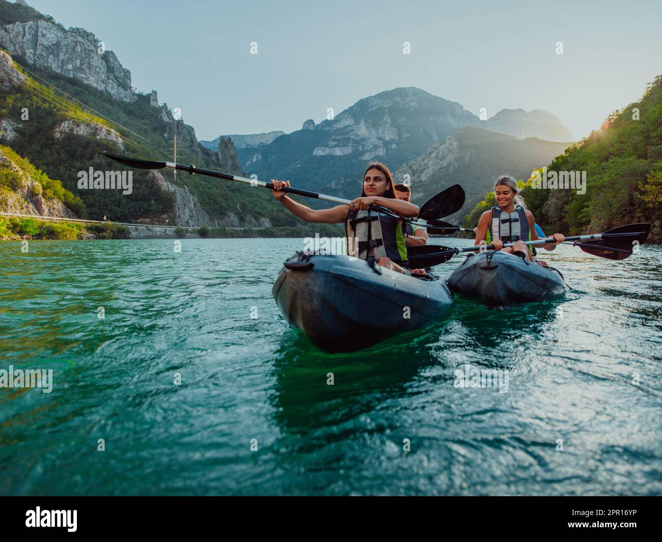 A group of friends enjoying fun and kayaking exploring the calm river ...