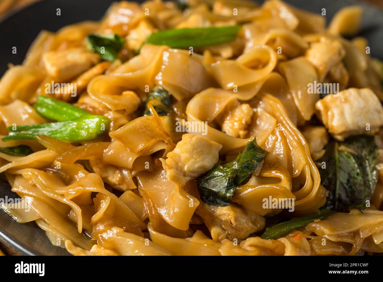 Spicy Homemade Thai Drunken Noodles with Chicken and Basil Stock Photo